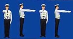 圖中警察手勢為減速慢行信號。
